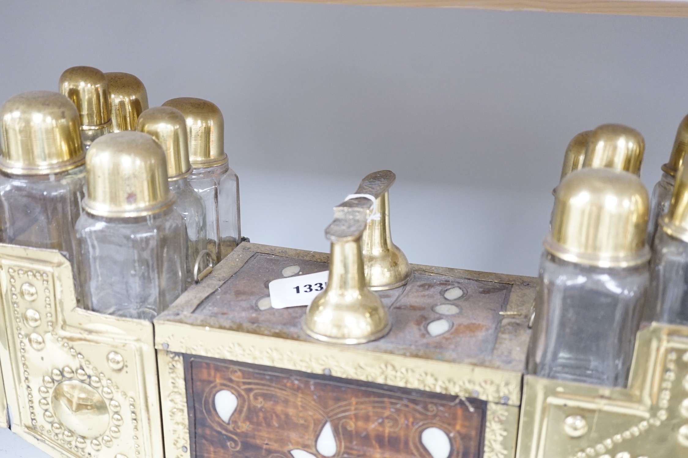 An Indian brass & hardwood shoe shiner's set, with twelve flasks. 57cm. long. 15cm. deep. 28cm. high